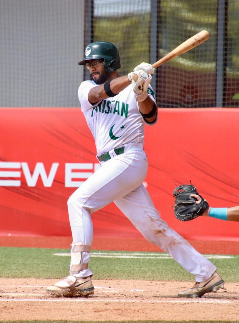 Pakistan batter swinging in white uniform