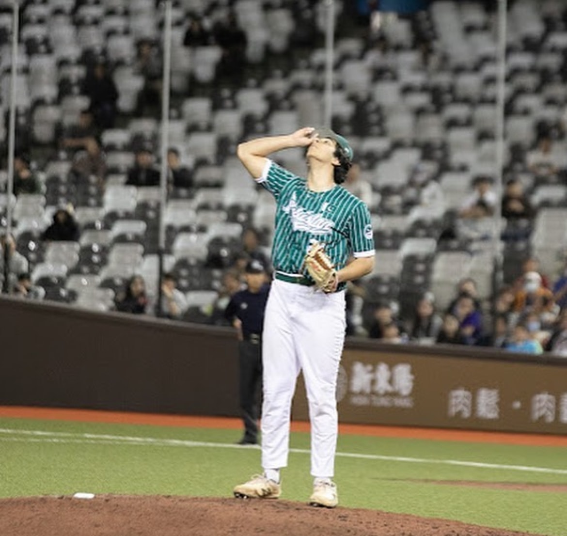 Pakistan pitcher on the mound at a night game stadium