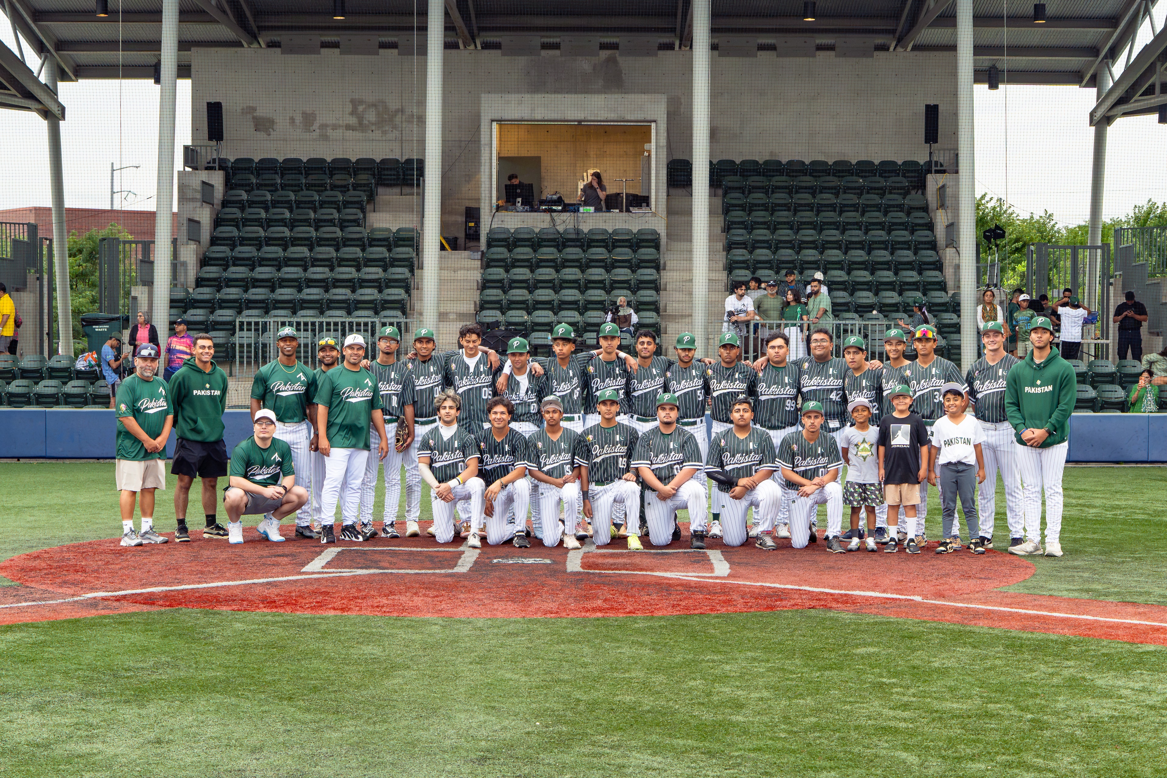 Full Pakistan Baseball team posing at home plate at the stadium